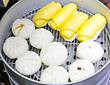 Chinese dumplings being steamed on the traditional pan