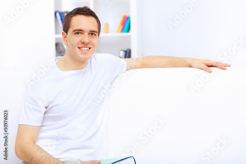Photo: Young man at home with a book Young man at home with a book