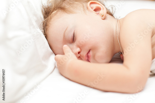 Photo: Restful two years baby girl sleeping on bed Restful two years baby girl sleeping on bed