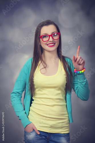 Photo: Brunettte in glasses pointing on something. Brunettte in glasses pointing on something.
