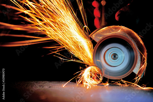 Photo: Worker cutting metal with grinder Worker cutting metal with grinder