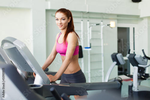 Photo: fitness model runs on treadmill, is engaged in fitness club fitness model runs on treadmill, is engaged in fitness club