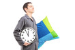 A young man with pillow and clock sleepwalking