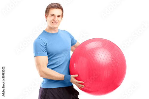 Photo: A young male athlete holding a pilates ball A young male athlete holding a pilates ball