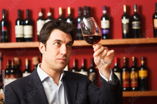 Photo: Sommelier examining a glass of red wine Sommelier examining a glass of red wine