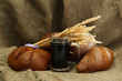 tankard of kvass and rye breads with ears, on burlap background