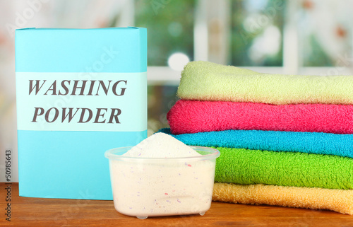 Photo: Box of washing powder with blue measuring cup and towels, Box of washing powder with blue measuring cup and towels,