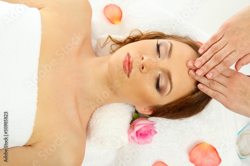 Photo: beautiful young woman in spa salon getting massage, isolated beautiful young woman in spa salon getting massage, isolated