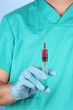 Doctor with syringe  on blue background