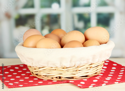 Photo: Many eggs in basket on table in room Many eggs in basket on table in room