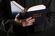 Priest reading from the holy bible, close up