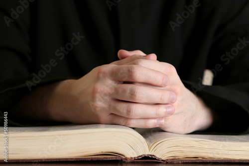 Photo: Priest reading from the holy bible, close up Priest reading from the holy bible, close up