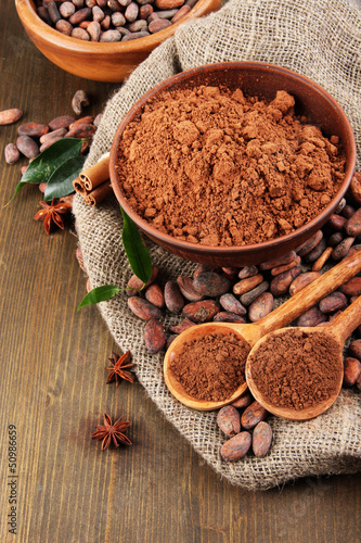 Photo: Cocoa powder and cocoa beans on wooden background Cocoa powder and cocoa beans on wooden background