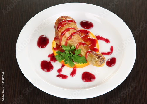 Photo: Small portion of food on big plate on wooden table Small portion of food on big plate on wooden table