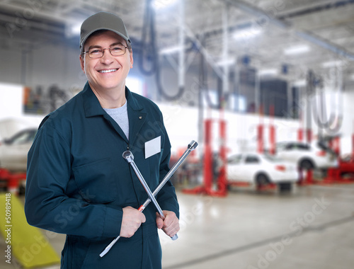 Photo: Auto mechanic with a wheel wrench. Auto mechanic with a wheel wrench.