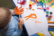 little boy painting with gouache on hand