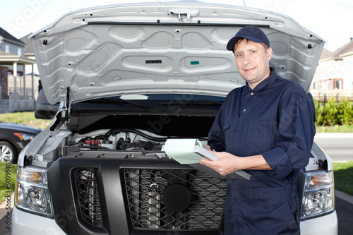 Photo: Car mechanic working in auto repair service. Car mechanic working in auto repair service.