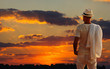 A young man standing on a rock and looking at the sunset of Phuk