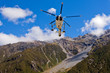 Rescue helicopter fly over mountainous wilderness