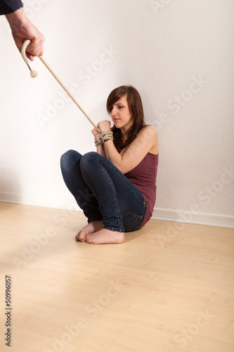 Photo: Das junge Mädchen ist an den Händen gefesselt Das junge Mädchen ist an den Händen gefesselt