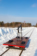 handcar on a narrow track in snow and blue sky