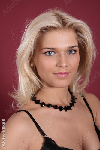 Photo: Portrait of the young girl, close up on a red background Portrait of the young girl, close up on a red background