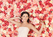 Foto: woman with bouquet and background full of roses woman with bouquet and background full of roses