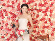 woman with bicycle and background full of roses