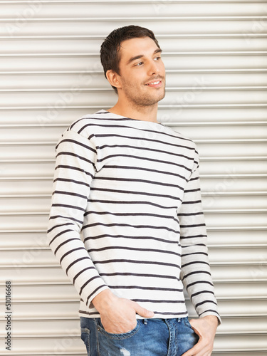 Photo: handsome man in casual clothes leaning to wall handsome man in casual clothes leaning to wall