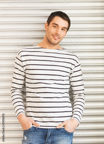 Photo: handsome man in casual clothes leaning to wall handsome man in casual clothes leaning to wall