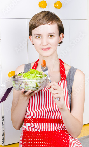 Photo: Health conscious woman eating green salad Health conscious woman eating green salad