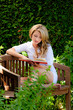 Frau beim Lesen eines Buches im Garten