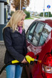 Frau beim tanken auf Tankstelle