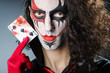 Evil clown with cards in dark room