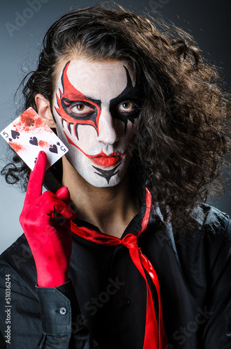 Photo: Evil clown with cards in dark room Evil clown with cards in dark room