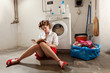 A housewife reading a book in the laundry room