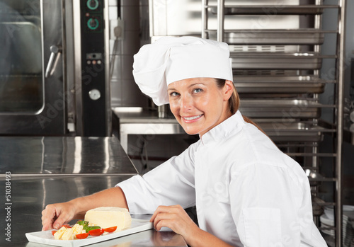 Photo: Female Chef With Dish At Counter Female Chef With Dish At Counter