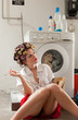A housewife reading a book in the laundry room
