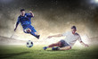 two football players striking the ball
