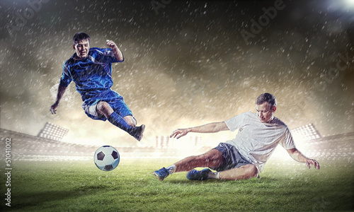 Photo: two football players striking the ball two football players striking the ball