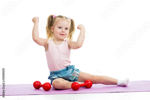 Photo: Child girl doing exercises with weights Child girl doing exercises with weights
