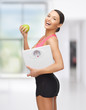 sporty woman with scale and green apple