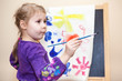 Photo: Thoughtful small Caucasian child holding painting brush in hand Thoughtful small Caucasian child holding painting brush in hand