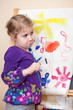 Photo: Funny small child with painting brush and thinking about picture Funny small child with painting brush and thinking about picture