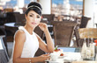 Woman in cafe restaurant with retro hairstyle and makeup