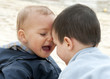 Two children,  small brother boys playing together outdoors.