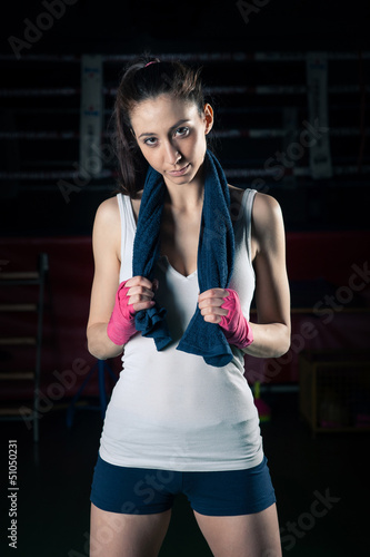 Photo: Boxing girl intense portrait against black background. Boxing girl intense portrait against black background.