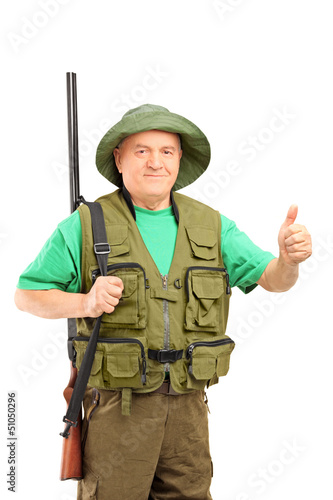 Photo: A mature hunter holding a rifle and giving a thumb up A mature hunter holding a rifle and giving a thumb up