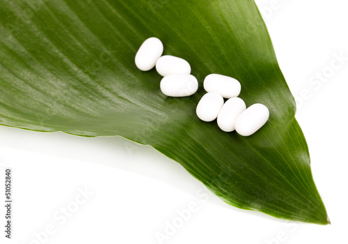Photo: tablets on green leaf isolated on white tablets on green leaf isolated on white
