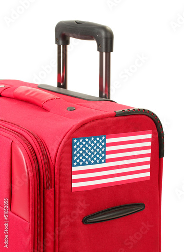 Photo: red suitcase with sticker with flag of USA isolated on white red suitcase with sticker with flag of USA isolated on white